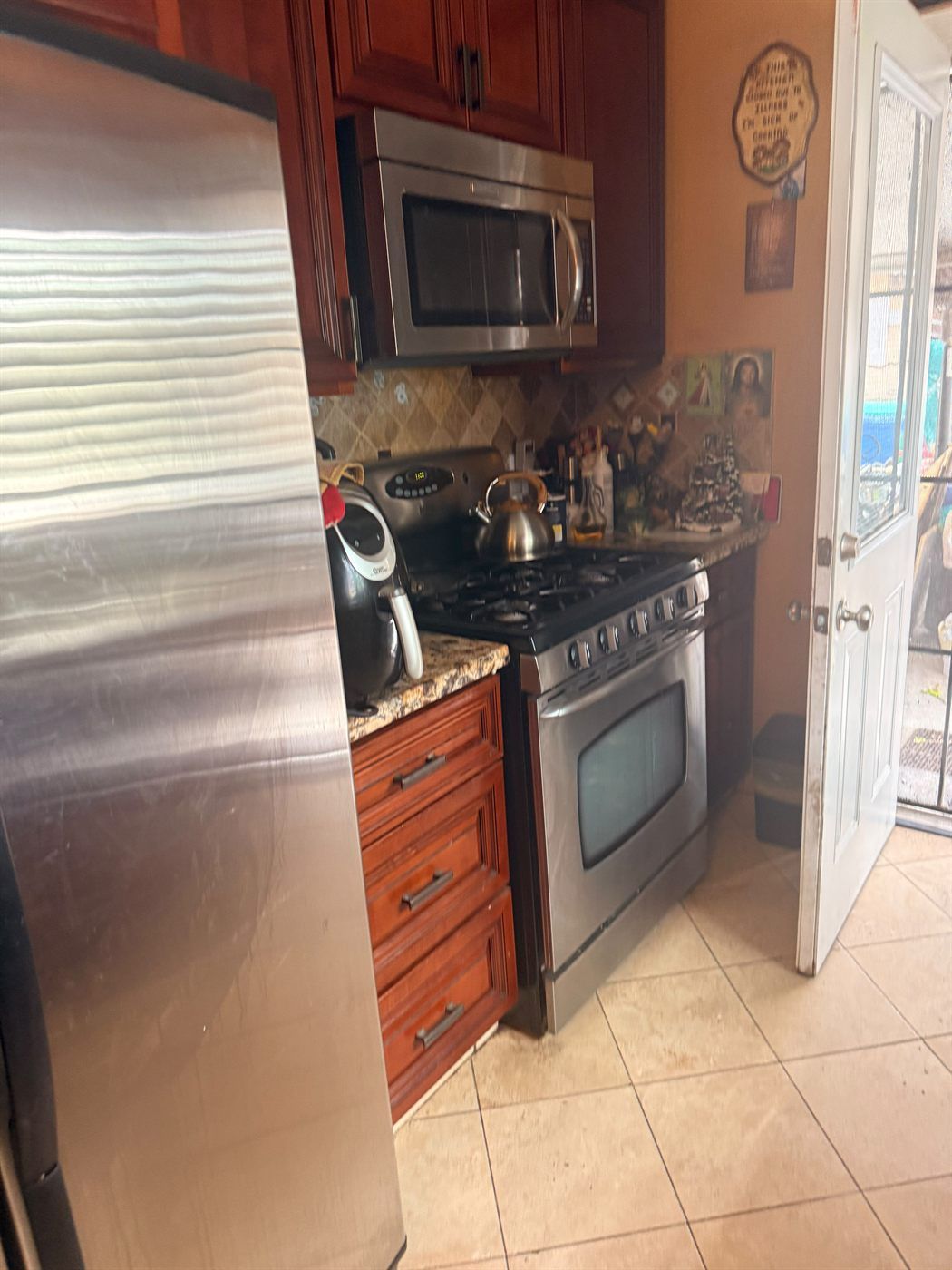 Kitchen with cherry cabinetry, granite counters and stainless appliances